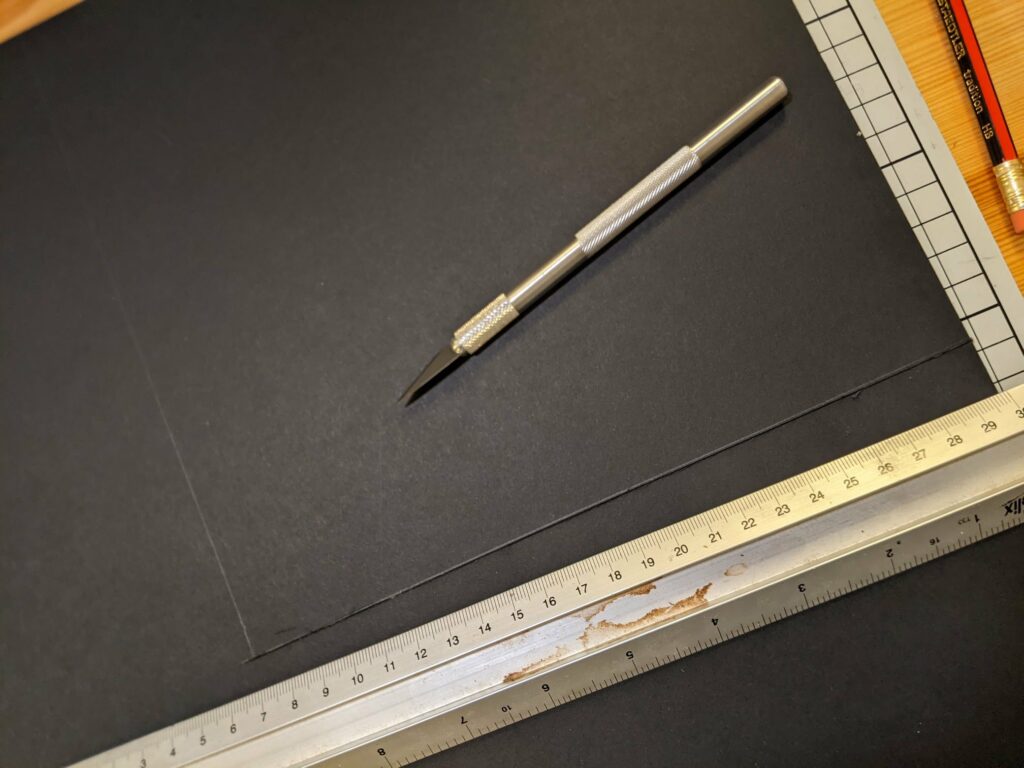 Silver pen and wooden pencils with measuring rulers on dark surface