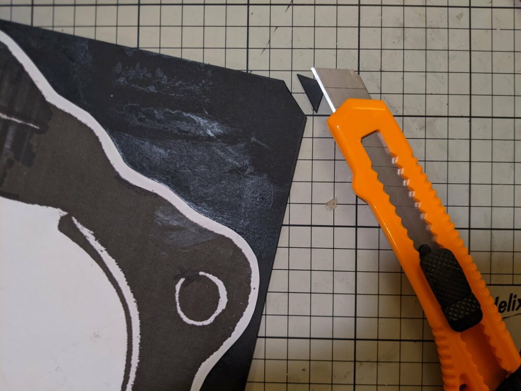 Orange pedalo boat handle on dark fabric with white patterns against a tiled background