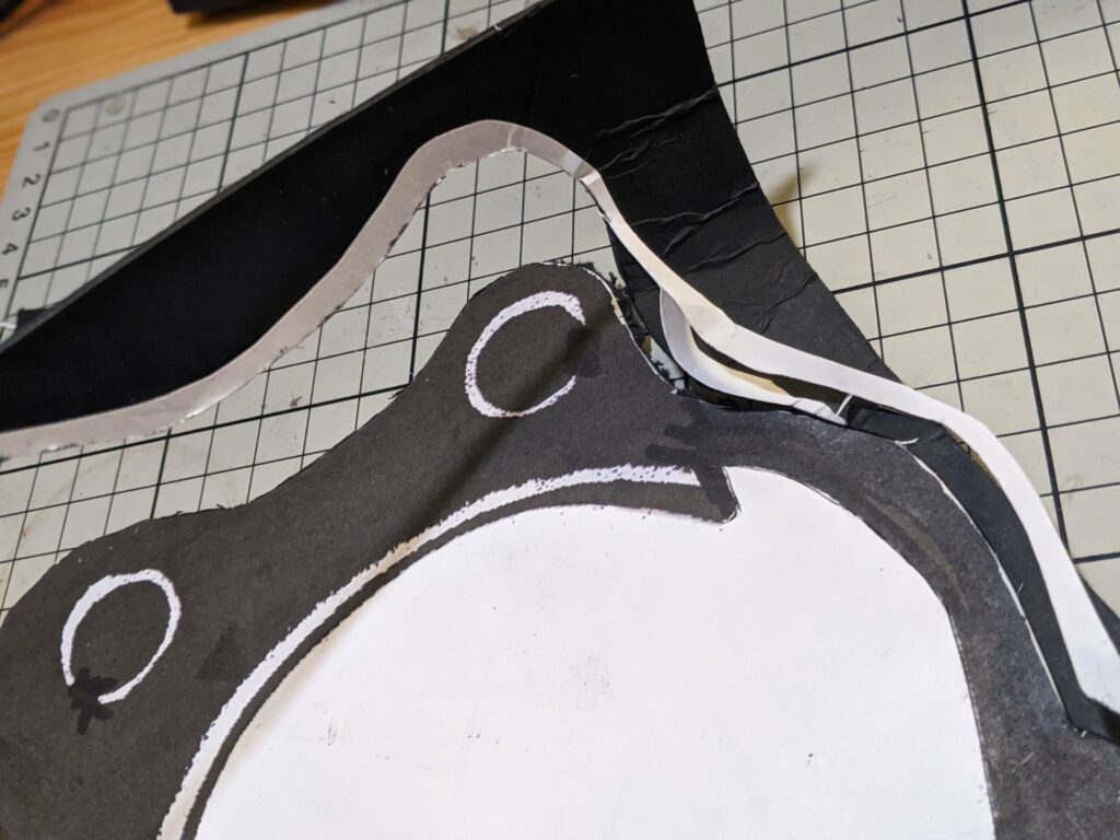 Puppet fabric pieces in black and white with white curved line markings and circular details on tiled background