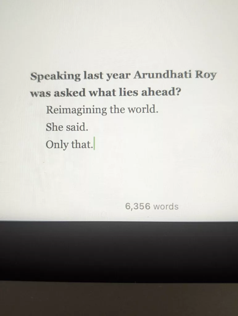 Text on a screen: Speaking last year Arundhati Roy was asked what lies ahead? Reimagining the world. She said. Only that. Word count: 6,356.