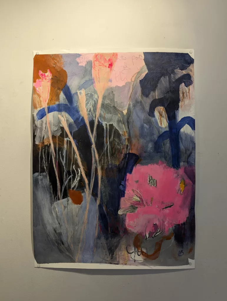 Abstract painting featuring long-stemmed pink flowers, blue foliage, and dark drips on a grey background, pinned to a white wall.